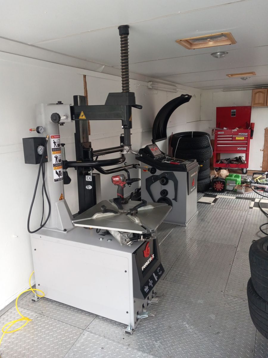 Interior of a service trailer with a tire changer machine and tire stock